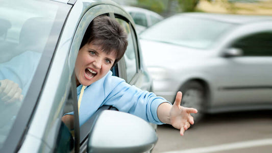 A woman expressing frustration while driving, representing stress related to traffic and the need to Normalize Your Stress Hormones.