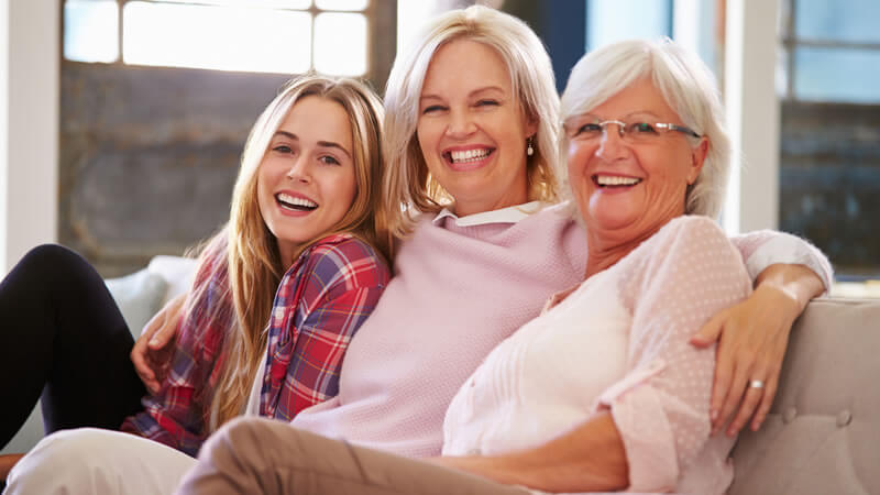 Three women of different ages sharing smiles and laughter, reflecting the joy of health and youth.