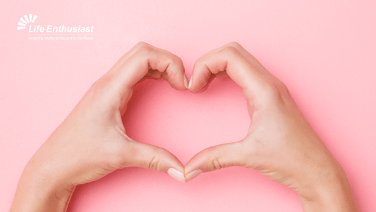 Hands forming a heart shape on a pink background for a wellness theme related to Chronic Pain and Biological Individuality.