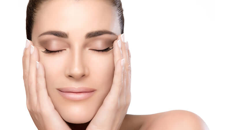 Woman applying Skin Sorcery Skin Care Ingredients on her face for a rejuvenating skincare routine.