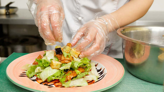 Preparing a fresh salad with safety gloves, highlighting the New Theory of Disease Food Safety.