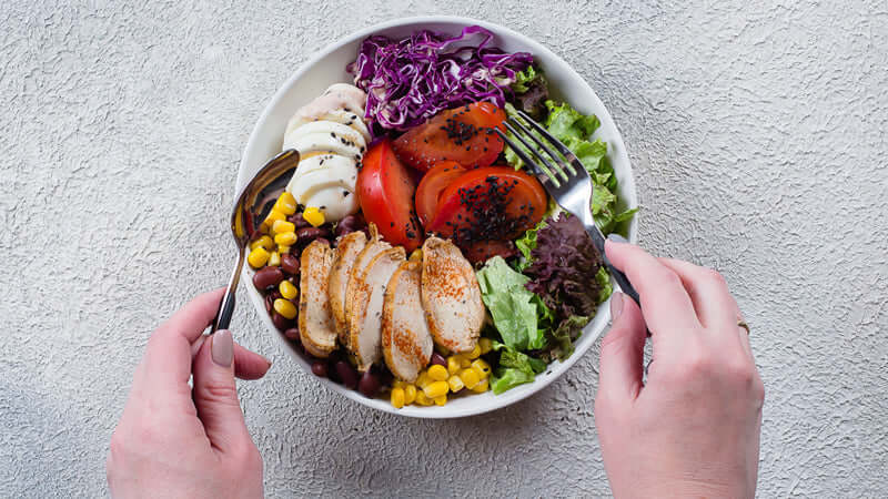 Delicious salad bowl showcasing Food Combining Principles with grilled chicken, mixed greens, and fresh vegetables.