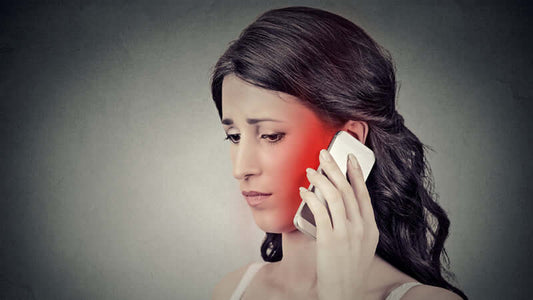 Concerned woman holding a phone, illustrating Cellphone Radiation Warnings and potential effects.