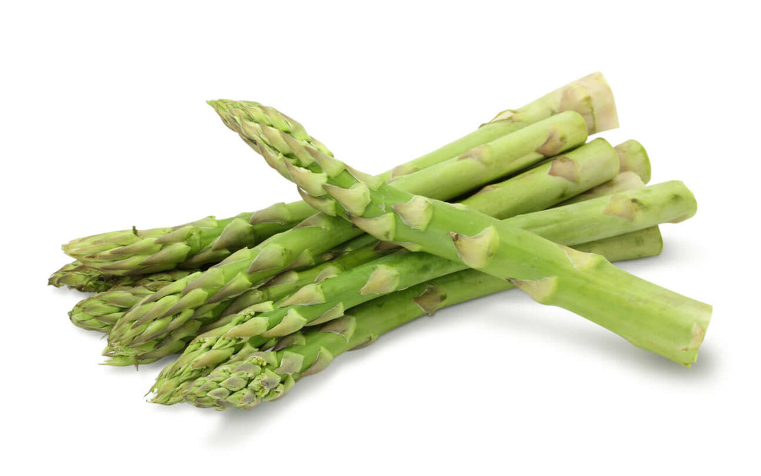 Fresh asparagus spears stacked on a white background, showcasing their vibrant green color.