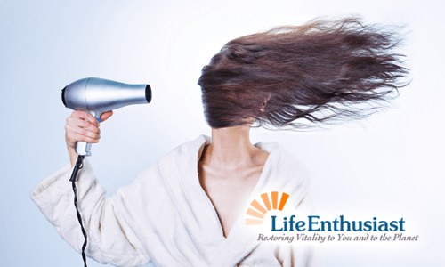 Person drying hair with a hairdryer, showcasing the essence of Nature's Guide to Beautiful Hair.