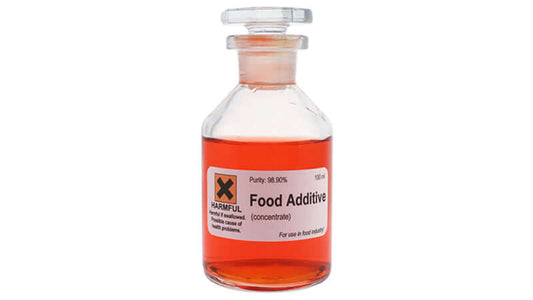 Clear bottle labeled 'Food Additive' with red liquid inside, indicating potential health risks.