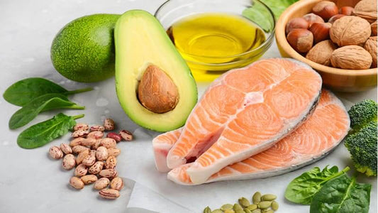 Essential Fats: Natural Sources including salmon, avocado, nuts, and olive oil on a table.
