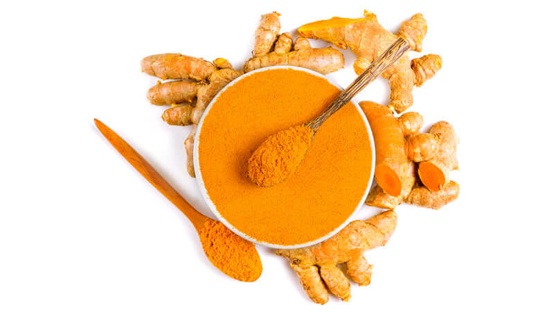 Turmeric powder and fresh turmeric roots on a white background, showcasing the vibrant color of Turmeric.