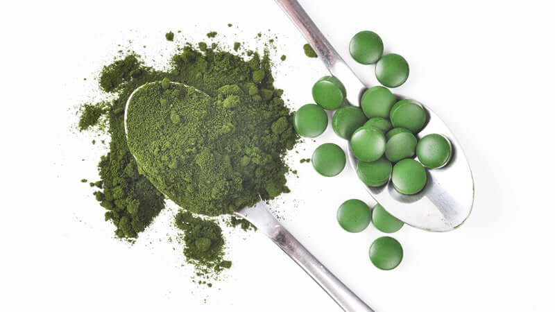 Calcium Fluoride powder and tablets displayed on spoons, showcasing natural supplements.