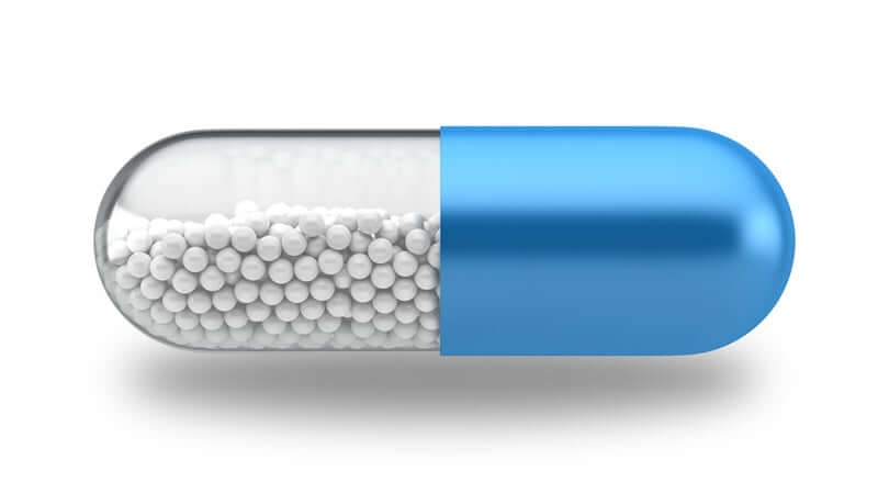 Close-up of a blue and clear capsule containing white beads, representing Cobalt supplement.