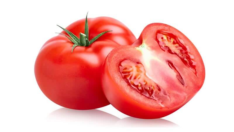 Fresh, ripe tomatoes cut in half, showcasing the juicy red interior, perfect for salads and cooking.