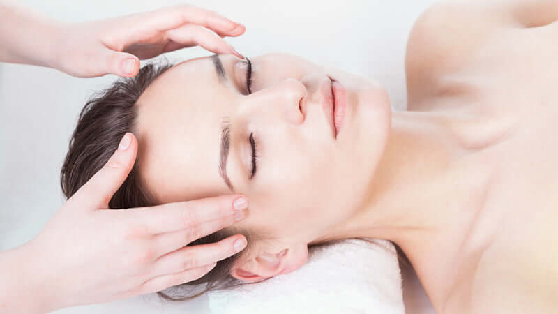 Aromatherapy Guide to Emotions: woman receiving a calming facial massage for relaxation and emotional balance.