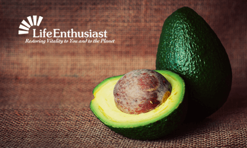 Avocado cut in half revealing seed, showcasing its creamy texture and vibrant green color.