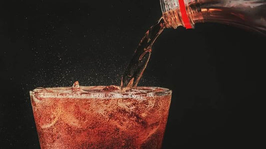 Carbonated Drinks-Pouring a carbonated drink into a glass with ice, showcasing bubbles and fizz.
