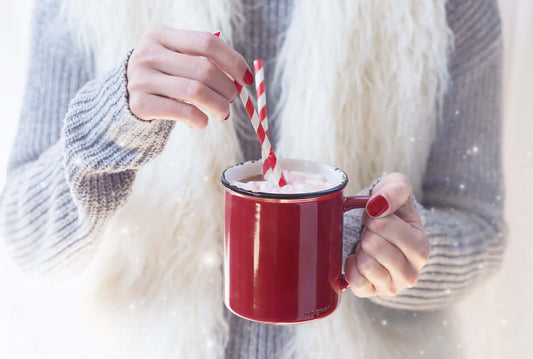 Another Aspartame Nightmare: a person stirring a drink in a red mug with a striped straw.