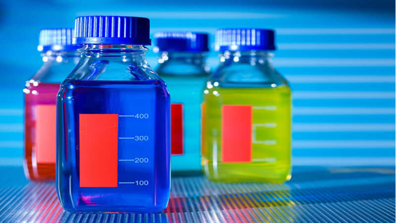 Colorful bottles containing liquids representing food additives for the article on Food Additives: The Dirty Dozen.