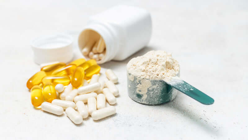 Various supplements including protein powder and capsules representing proteins, enzymes, and amino acids.