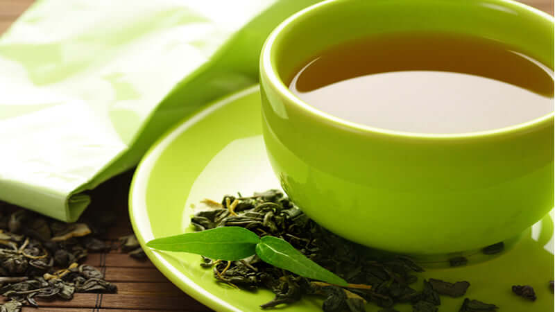 Dr. Miller Tea Before and After, a green tea cup with loose tea leaves and a green saucer.