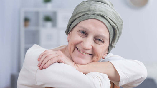 A smiling woman with a headscarf representing resilience in the discussion of Glutathione and Cancer.