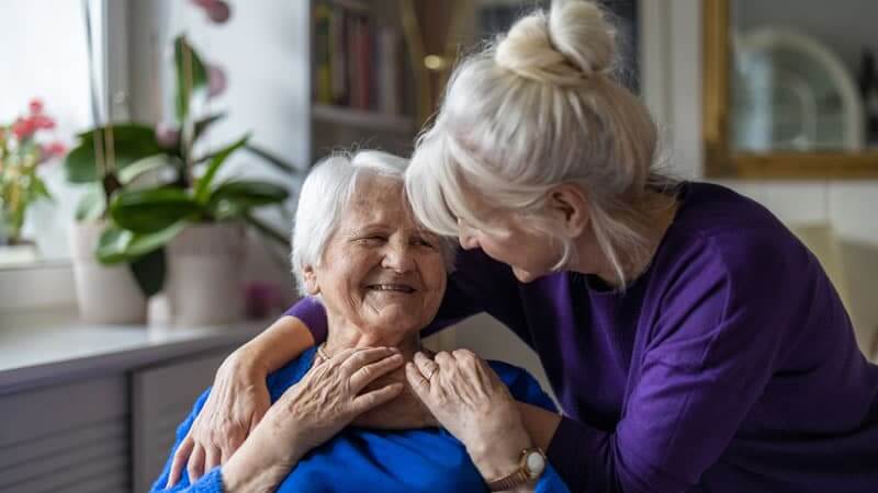 Older woman smiling with a caregiver, illustrating the bond while discussing how Magnesium Helps Fight Dementia.