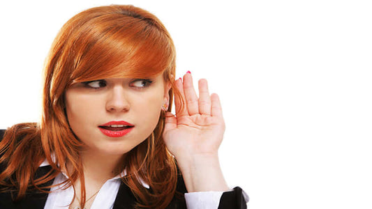 Woman holding her hand to her ear, listening intently to Secret Sounds That Heal.