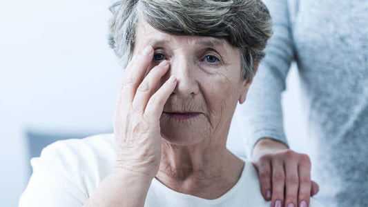 An elderly woman touching her face, depicting symptoms of Meniere's Syndrome and the impact on daily life.