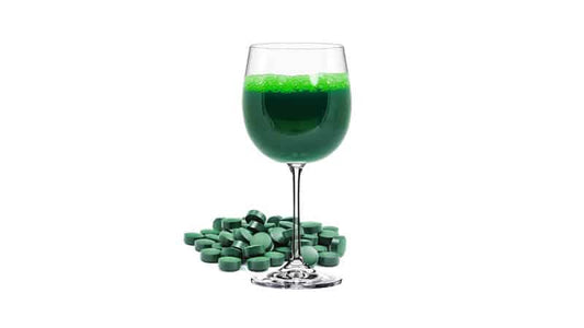 Green drink in a glass with algae tablets, representing Algae and Seaweed Target Nutritional Deficiencies.