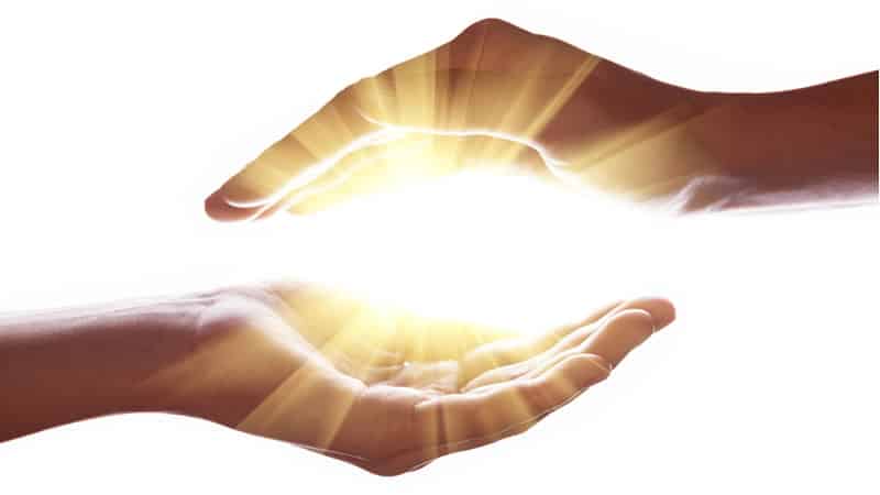 Two hands creating a protective barrier with a glowing light, symbolizing Magnesium and Radiation Protection.