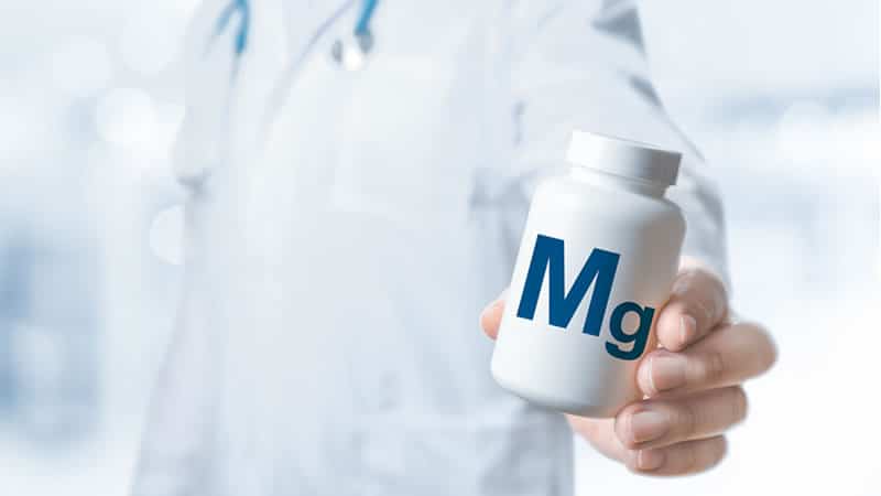 Doctor holding magnesium supplement bottle for article on Magnesium in Acute and Chronic Diseases.
