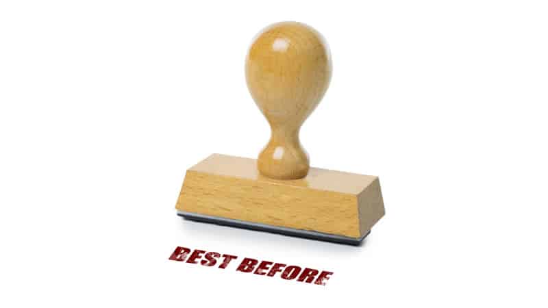 Wooden stamp reading 'BEST BEFORE' illustrating supplement expiry dates.