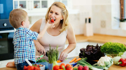 Fructo, Mother and child enjoying healthy vegetables together while preparing a meal in the kitchen, fostering healthy eating habits.