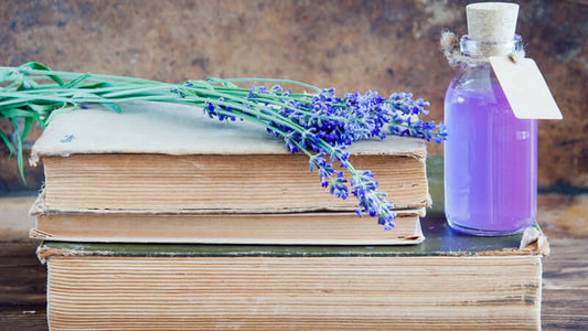 Aromatherapy Guide by Function with lavender flowers and essential oil on vintage books.