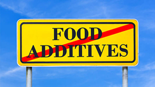 Book Excitotoxins the Taste that Kills - Sign warning against food additives, emphasizing cautious consumption related to health concerns.