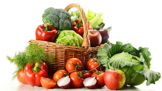 Basket full of fresh vegetables representing the Raw Food Movement, including peppers, lettuce, and tomatoes.