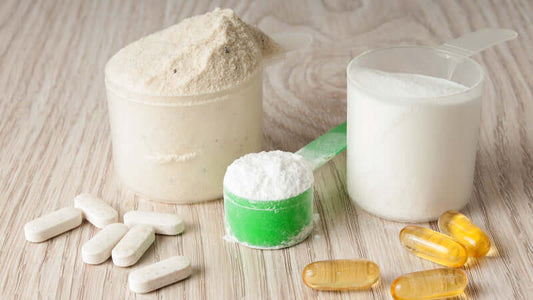 Amino Acids supplements in various forms including powder, capsules, and tablets on a wooden surface.