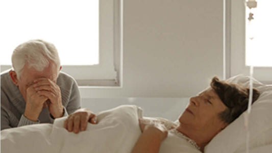 Emotional scene depicting a man mourning beside a woman in bed, representing the concept of Lifespan Crisis.