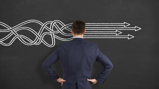 A man in a suit looking at a chalkboard illustrating the Power of Knowledge for Health and decision-making pathways.