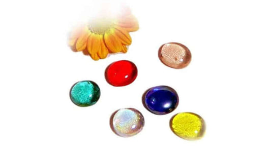 A collection of colorful stones with a flower, representing Lebens Quelle Energy Cells.