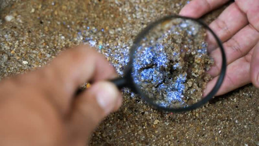 Close-up of silica sand under a magnifying glass, highlighting its unique texture and shine. Silica - the Microbes Kiss.