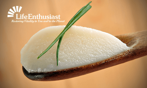 Praise The Lard on a wooden spoon with a green garnish, promoting healthy cooking.