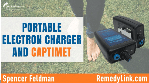Portable Electron Charger and Captimet showcased on grass with feet nearby.