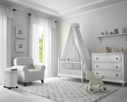 Nursery room with white furniture, crib, and toys in a bright room.