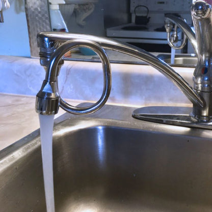 Chrome kitchen faucet with water running into a sink