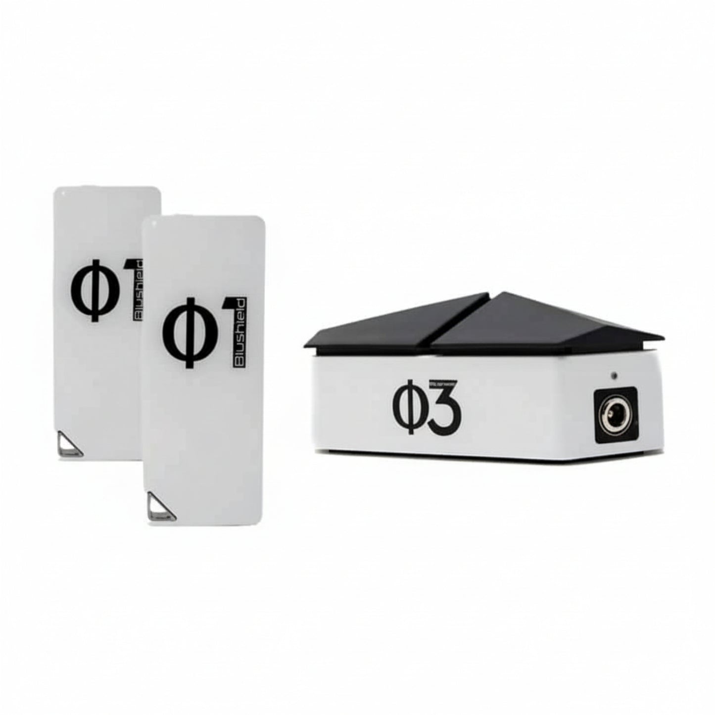 three white devices for EMF protection, two look like cell phones and say Φ1 Blushield, the other has a black top like a roof and says Blushield Φ3
