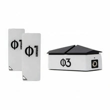 three white devices for EMF protection, two look like cell phones and say Φ1 Blushield, the other has a black top like a roof and says Blushield Φ3