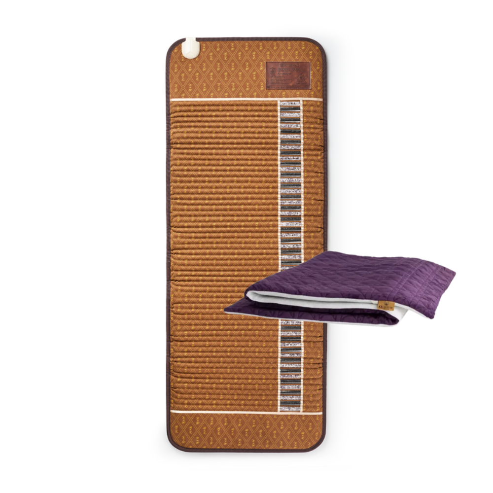 A brown woven cooling mat with a vertical channel of black cooling pads, shown next to a folded purple quilted blanket on a white background.