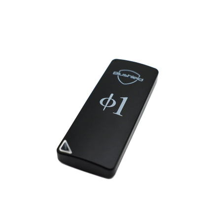 A black rectangular electronic device with rounded corners, featuring the 'bushido' brand name and shield logo, a silver phi1 symbol, and a small white triangle indicator on a plain white background.