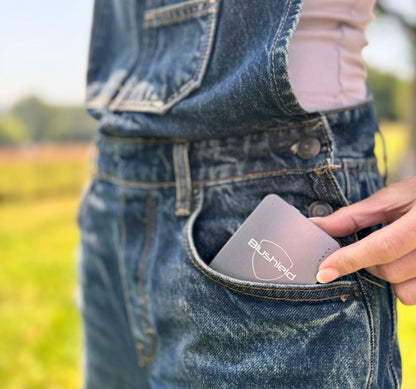 Person holding the Ultimate Portable device in a denim pocket, showcasing its compact design for personal EMF protection.