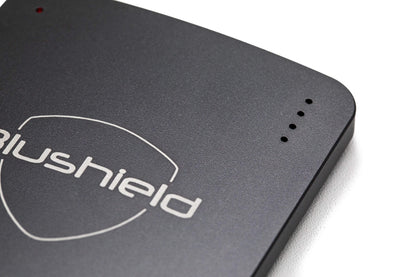 Close-up of the Blushield Ultimate Portable, a compact rechargeable device for personal EMF protection.