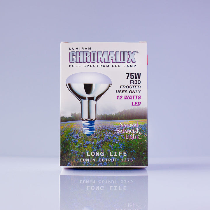 Lumiram Chromalux 75W R30 frosted LED lamp packaging box, featuring a silver reflector bulb graphic over a purple field landscape, on a light lavender background with a soft reflection below.